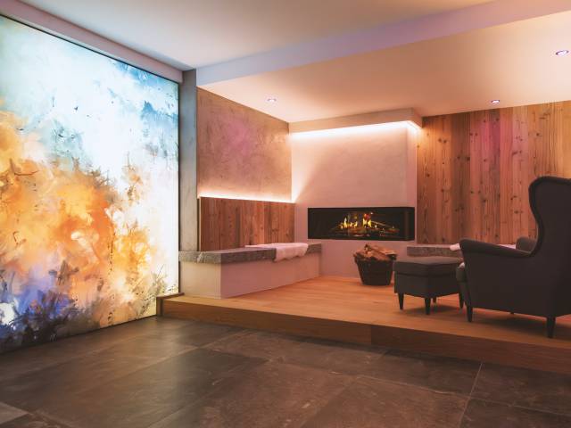 Ruhebereich mit Sessel und Kamin im Posthotel Erlerwirt