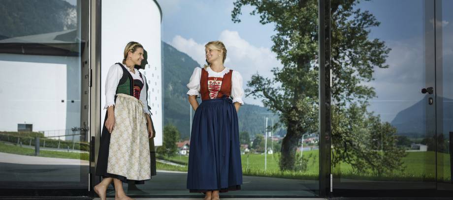 Frauen im Dirndl stehen vor Gläserner Tür