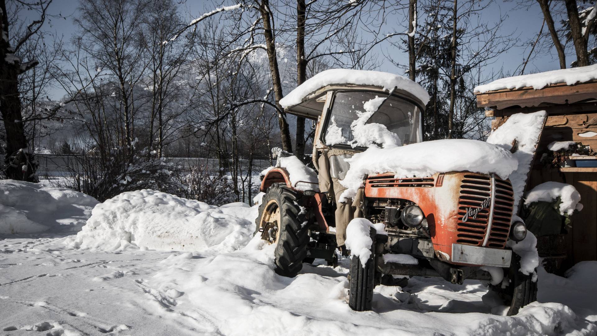 Verschneiter Traktor auf dem Feld im Winter