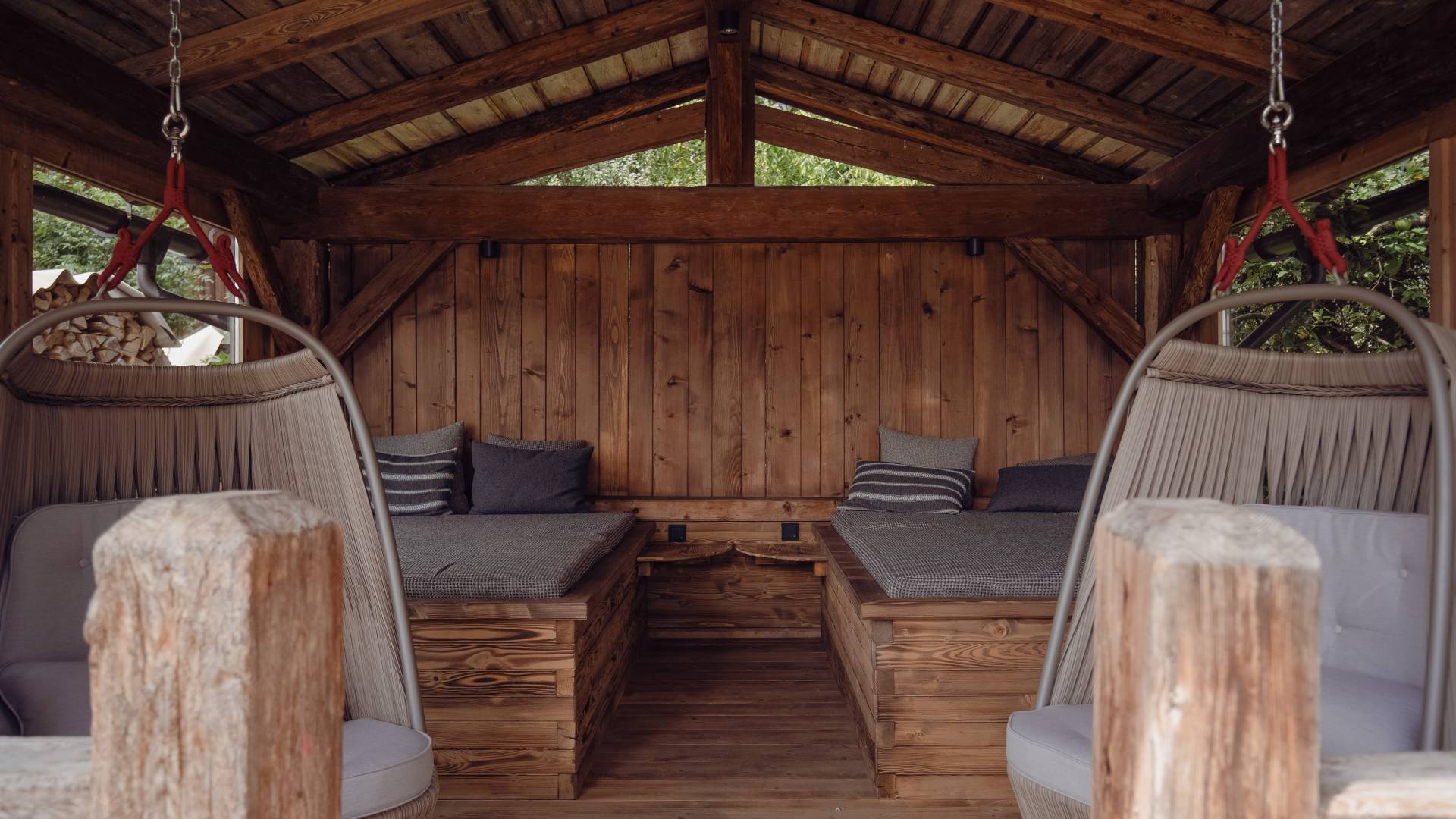 Holzhütte mit Ruheliegen und Hängesesseln im Posthotel Erlerwirt